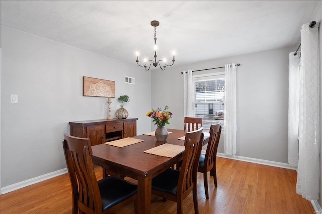 dining area featuring a chandelier and light hardwood / wood-style floors