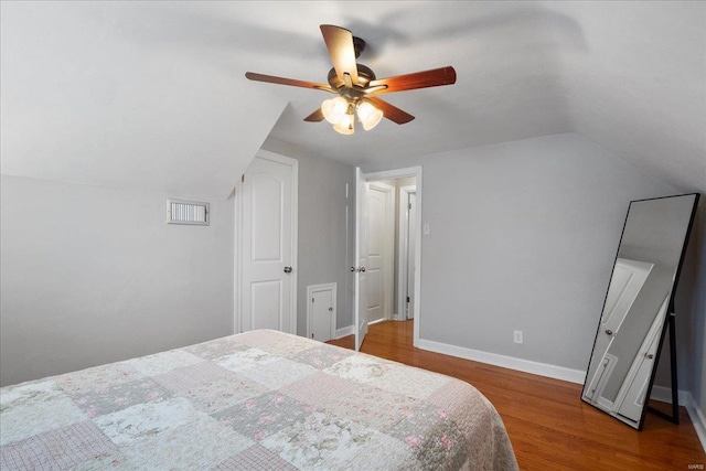 bedroom with ceiling fan, lofted ceiling, and hardwood / wood-style floors