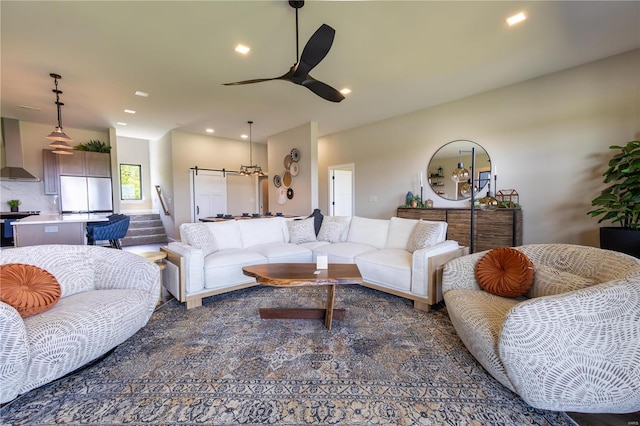 living room with ceiling fan and a barn door