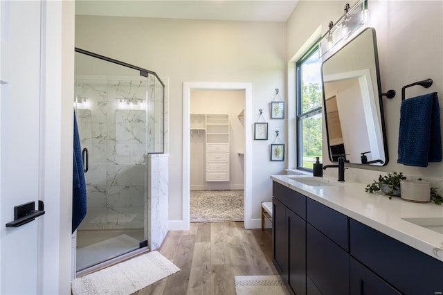 bathroom featuring hardwood / wood-style flooring, vanity, and an enclosed shower