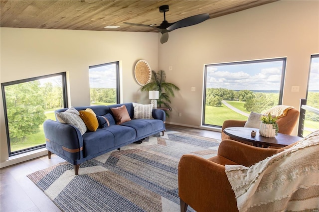 living room with ceiling fan, light hardwood / wood-style floors, and wooden ceiling