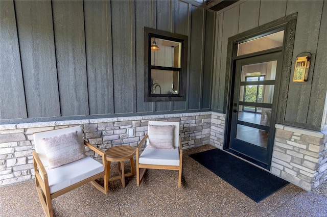 entrance to property featuring board and batten siding and stone siding