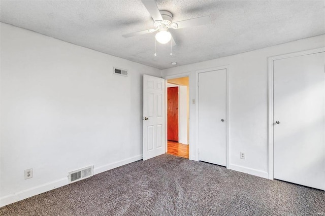 unfurnished bedroom featuring ceiling fan, carpet floors, and a textured ceiling