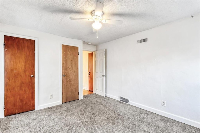 unfurnished bedroom with ceiling fan, carpet floors, and a textured ceiling