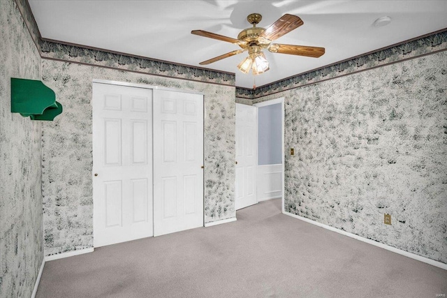 unfurnished bedroom with ceiling fan, carpet flooring, and a closet