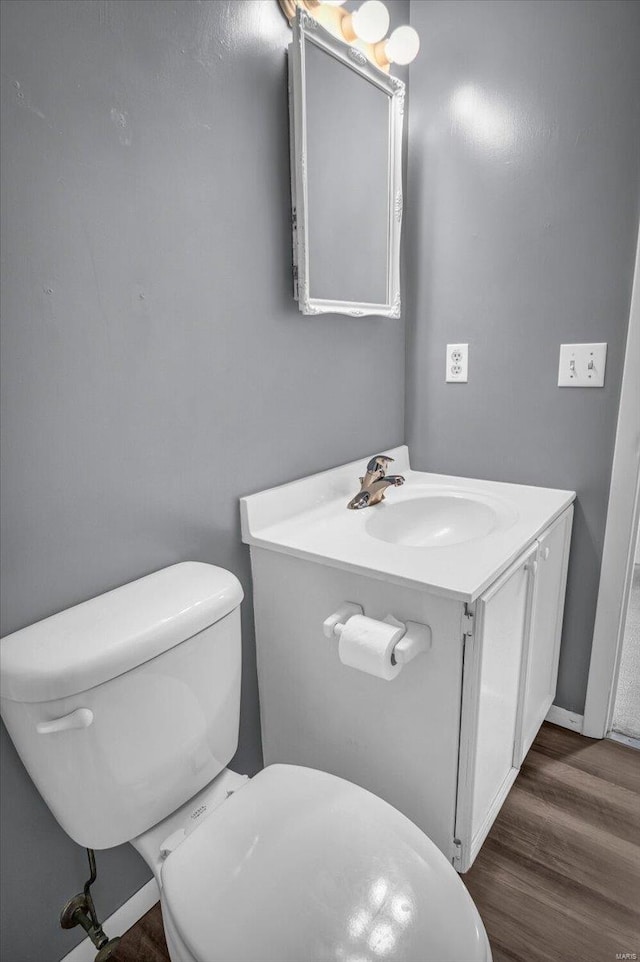 bathroom with wood-type flooring, vanity, and toilet