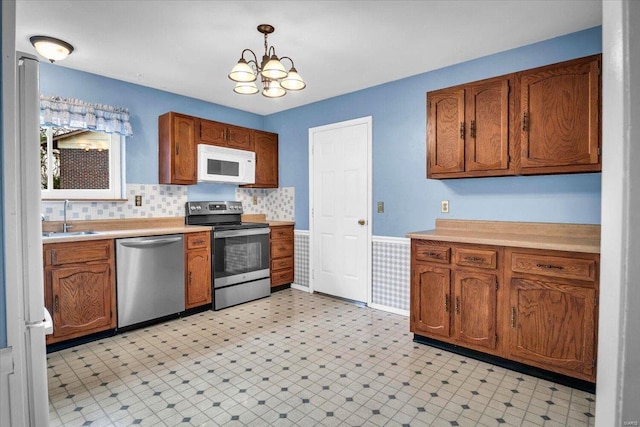 kitchen featuring hanging light fixtures, a notable chandelier, sink, and appliances with stainless steel finishes