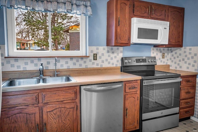 kitchen featuring tasteful backsplash, sink, and appliances with stainless steel finishes