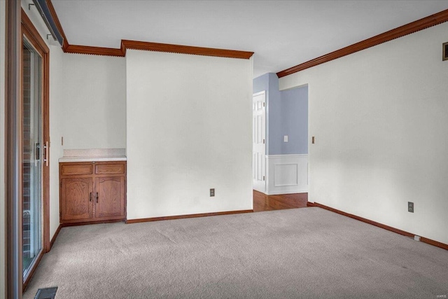 carpeted spare room featuring ornamental molding