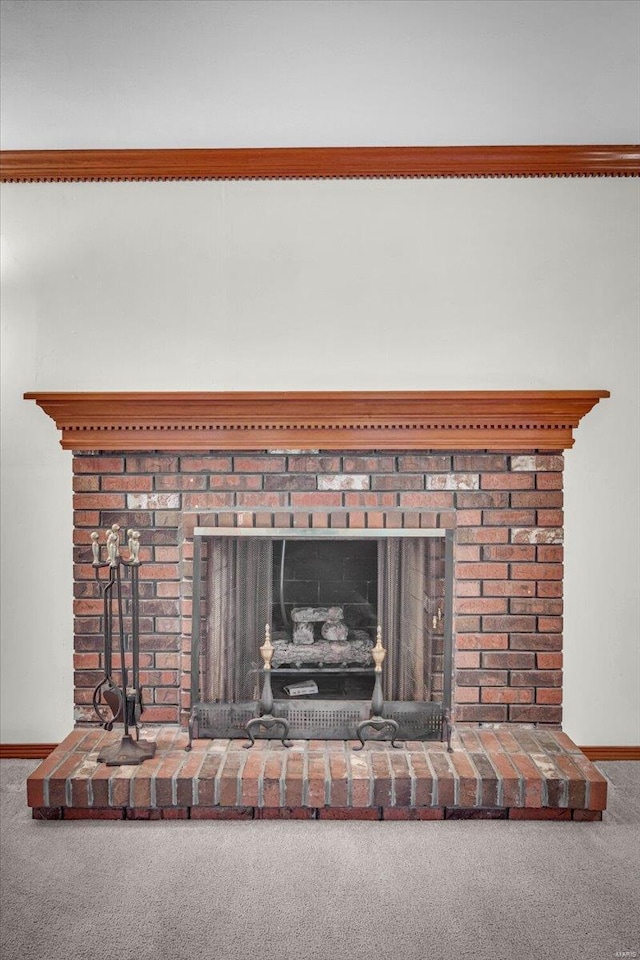 interior details featuring a brick fireplace and carpet floors