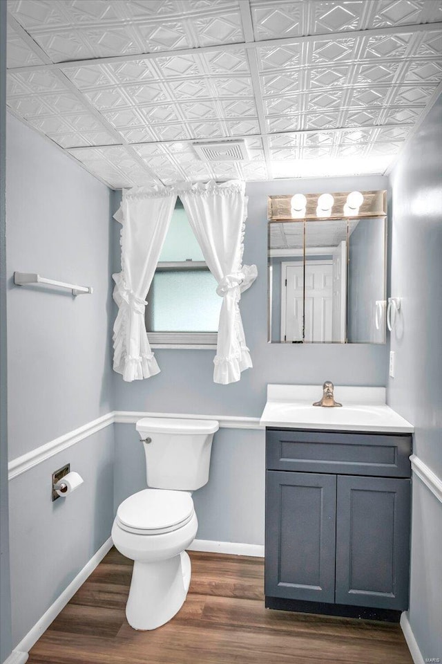 bathroom with vanity, hardwood / wood-style flooring, and toilet