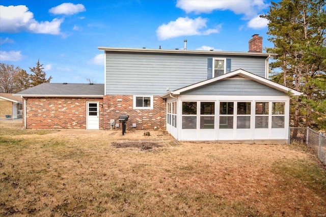 back of house with a sunroom and a yard