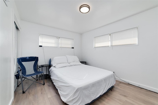 bedroom with light hardwood / wood-style floors and a closet