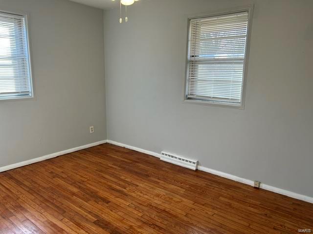 spare room with dark hardwood / wood-style flooring and ceiling fan