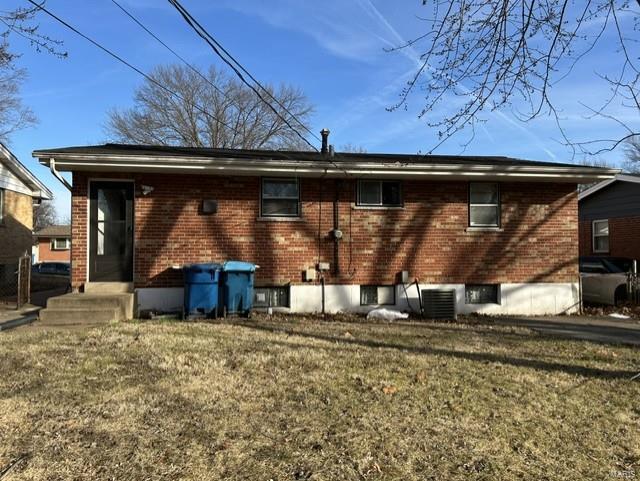 back of house with central AC and a lawn