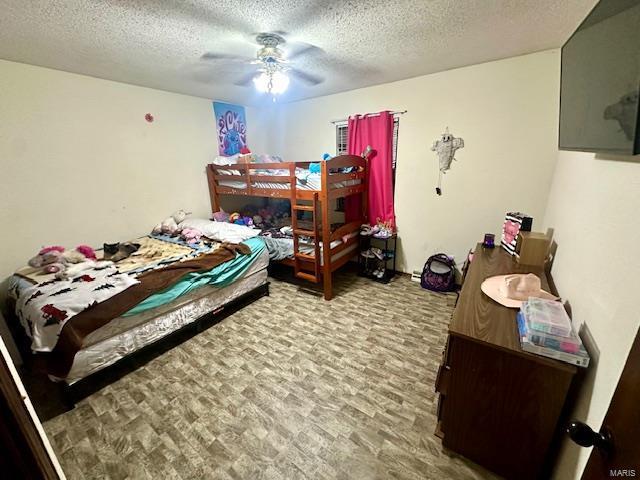 bedroom with ceiling fan and a textured ceiling