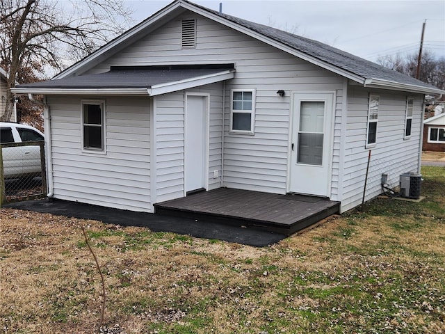 rear view of house with a yard and central air condition unit