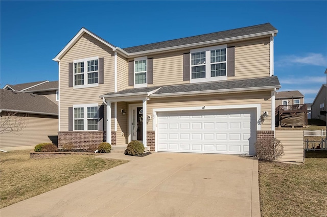 traditional-style house with a garage, concrete driveway, brick siding, and fence