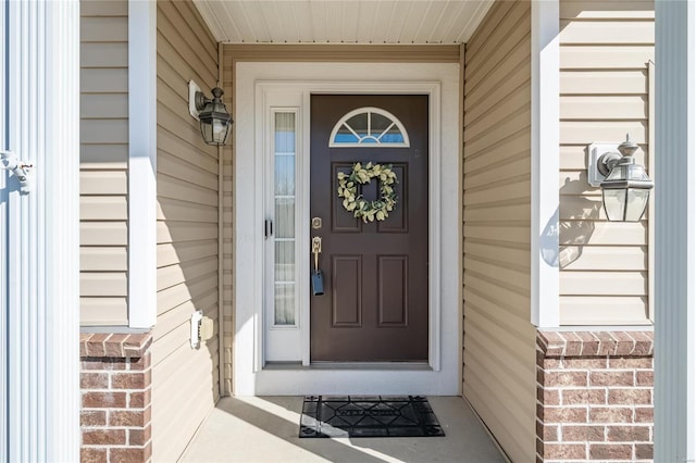 doorway to property featuring brick siding