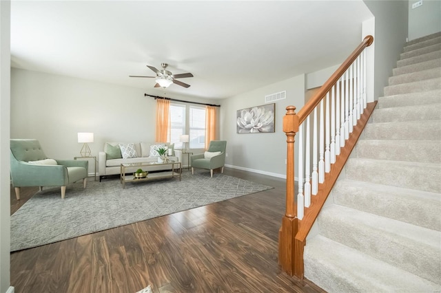 living area with visible vents, baseboards, ceiling fan, stairway, and wood finished floors