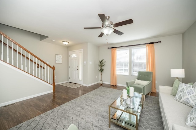 living area featuring baseboards, visible vents, ceiling fan, stairway, and wood finished floors