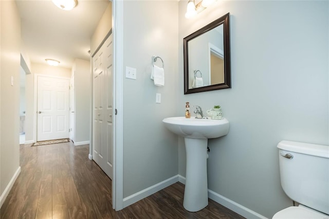 bathroom with a sink, wood finished floors, toilet, and baseboards