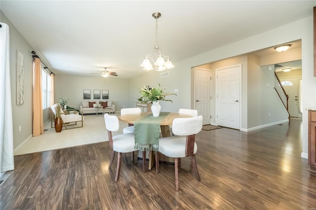 dining space featuring visible vents, dark wood finished floors, baseboards, and ceiling fan with notable chandelier