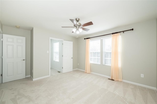 unfurnished bedroom with light carpet, ceiling fan, and baseboards