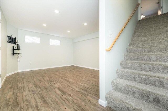 below grade area featuring stairs, wood finished floors, and baseboards