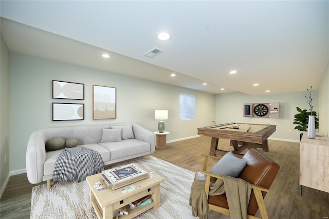 living room with recessed lighting, visible vents, baseboards, and wood finished floors