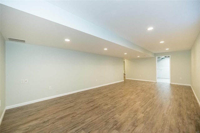 empty room featuring baseboards, visible vents, wood finished floors, and recessed lighting