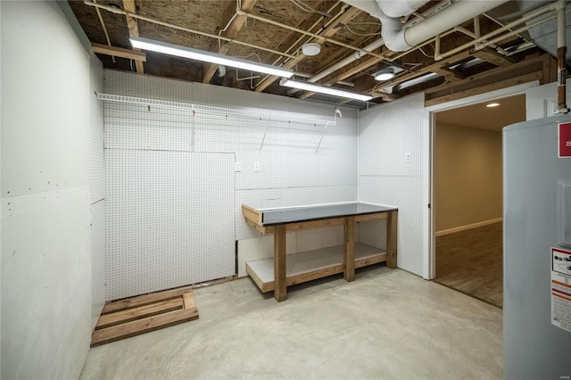 unfinished basement featuring a workshop area and electric water heater