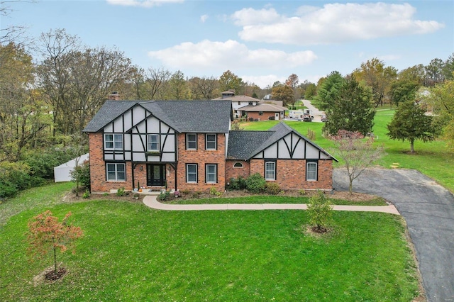 english style home featuring a front yard