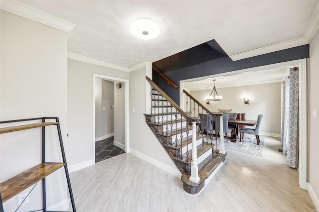 stairs with crown molding, hardwood / wood-style floors, and a notable chandelier