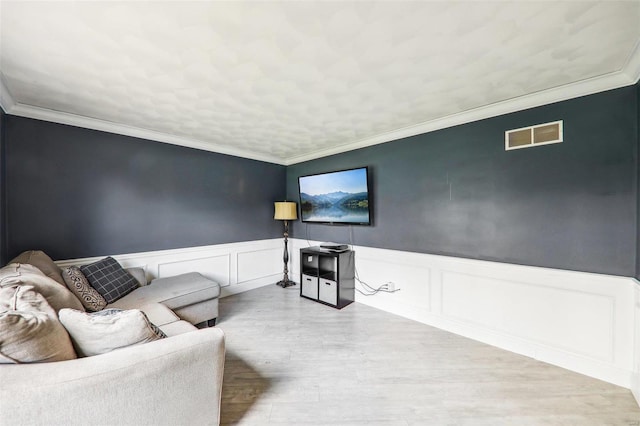 living room featuring ornamental molding and light wood-type flooring