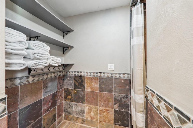 interior space featuring tile walls and a shower with shower curtain