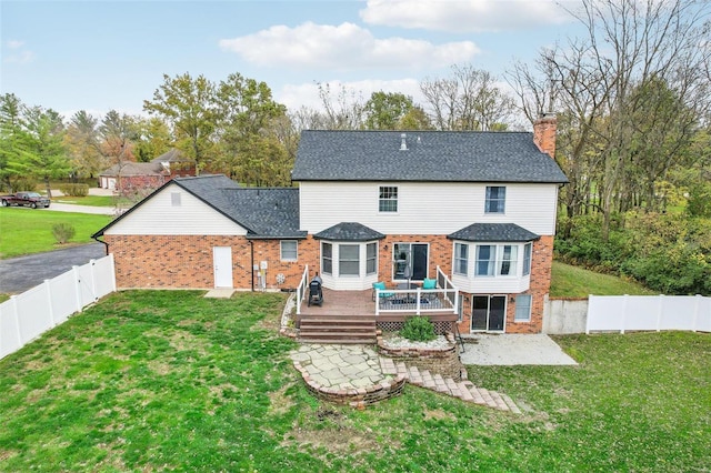 rear view of house featuring a yard and a deck