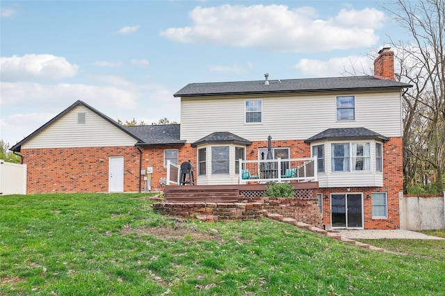 rear view of property featuring a yard and a deck