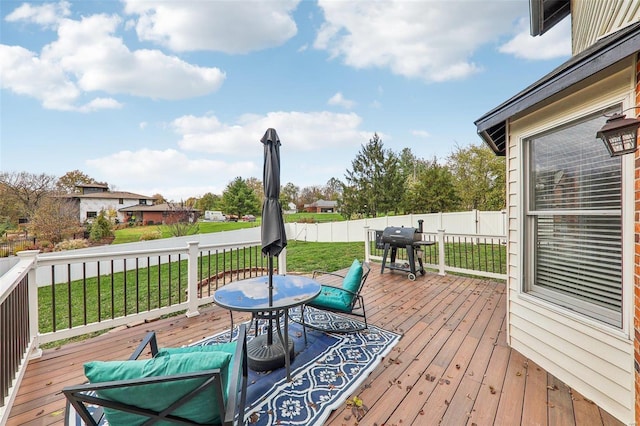 wooden deck featuring grilling area and a lawn