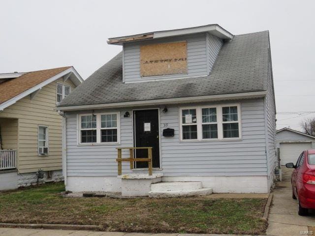 bungalow-style house with a garage and an outdoor structure