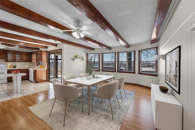 dining room with ceiling fan, light hardwood / wood-style flooring, and a textured ceiling