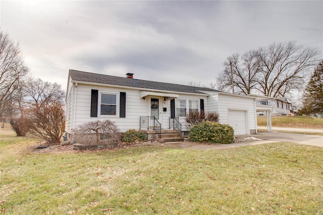 view of front of property with concrete driveway, a chimney, an attached garage, and a front yard