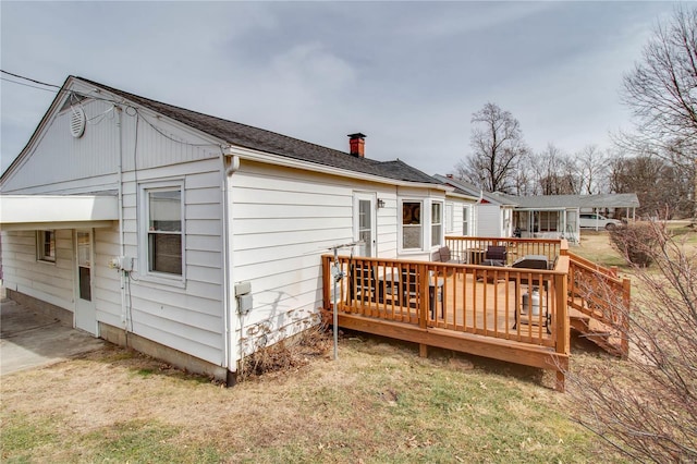 back of house featuring a chimney and a wooden deck