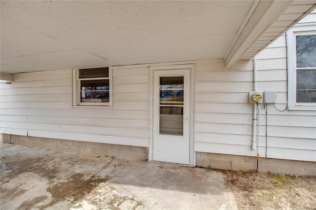 view of exterior entry with a patio