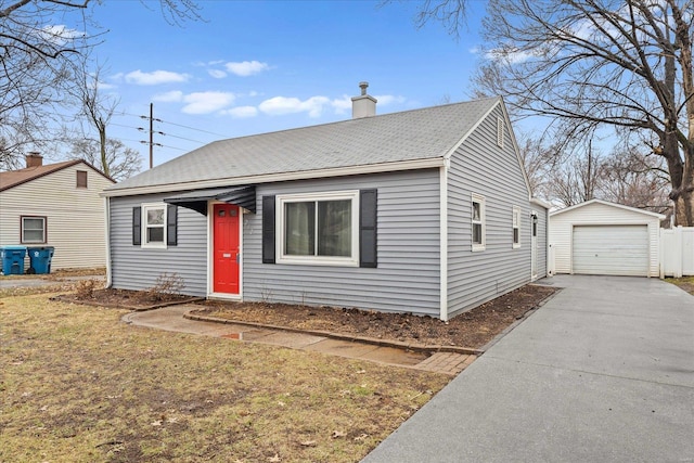 view of front of home with a garage, an outdoor structure, and a front lawn