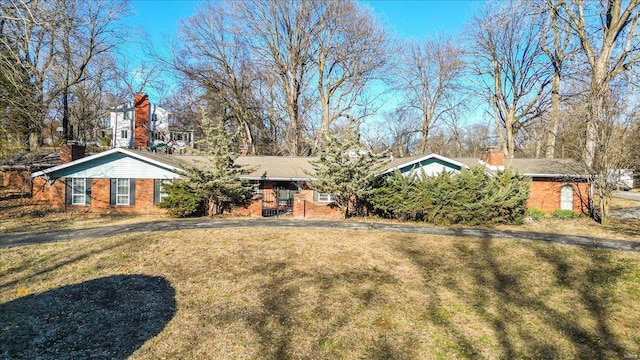 view of front facade with brick siding and a front yard