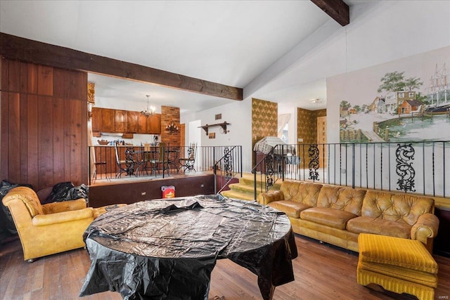 interior space featuring stairway, wood finished floors, lofted ceiling with beams, and an inviting chandelier