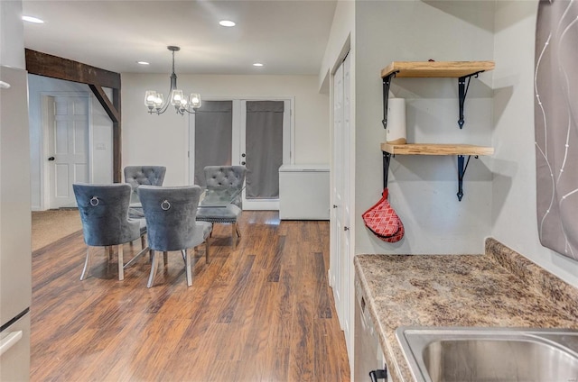 dining area featuring dark wood-type flooring and a chandelier