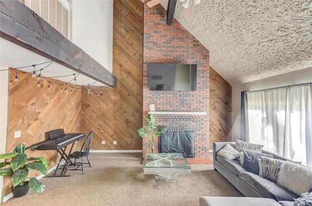 carpeted living room with wood walls, high vaulted ceiling, a textured ceiling, beamed ceiling, and a fireplace