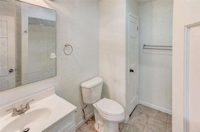 bathroom featuring vanity, tile patterned floors, and toilet